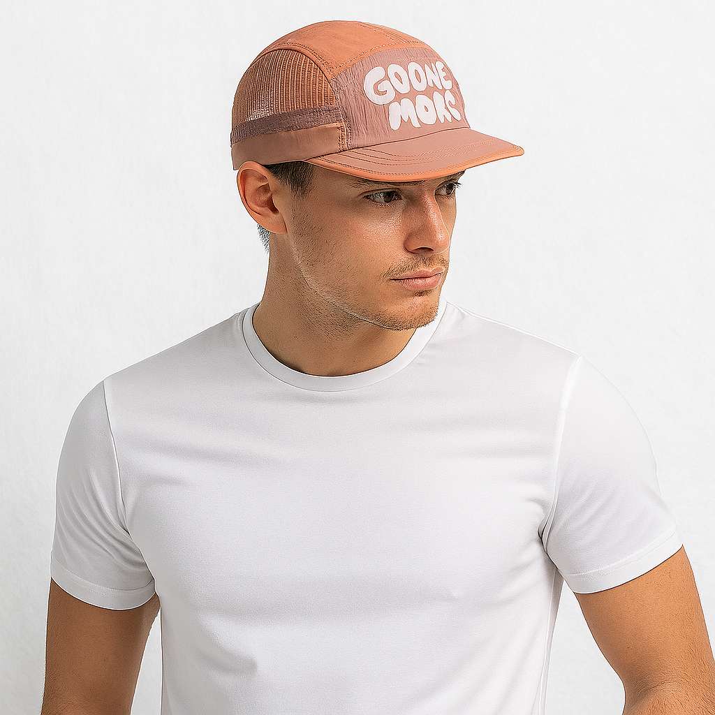 Un homme porte la Casquette 5 Panel Trail rose saumon
