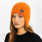 Une femme porte le Bonnet Cache Oreille en Laine Orange 