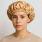 Une femme porte le Bonnet en Satin Gold Réglable