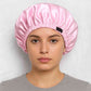 Une femme porte le Bonnet en Satin Rose Pale Réglable
