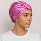 Une femme porte le Bonnet en Satin Rose Papillon 