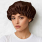 uNE FEMME PORTE LE Bonnet en Soie Marron Charlotte
