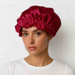 Une femme porte le Bonnet en Soie Rouge Charlotte 