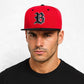 Un homme porte la Casquette Basket Snapback rouge