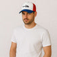 Un homme porte la Casquette Pécheur poisson bleu blanc rouge