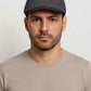 Un homme porte la Casquette Plate Homme Grise