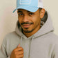 Un homme porte la Casquette Trucker Smiley bleu ciel